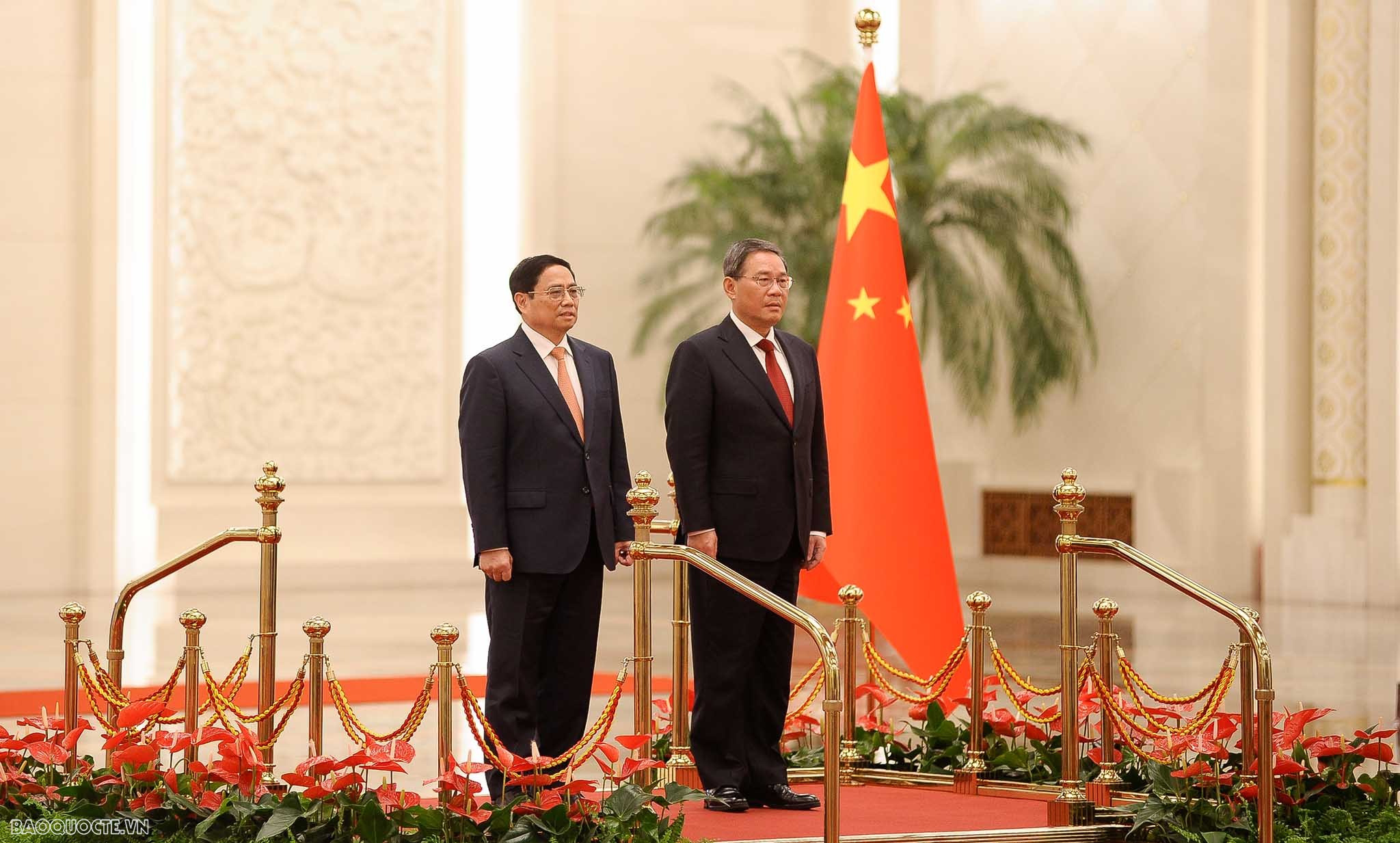 Thủ tướng Lý Cường mời Thủ tướng Phạm Minh Chính bước lên bục danh dự.