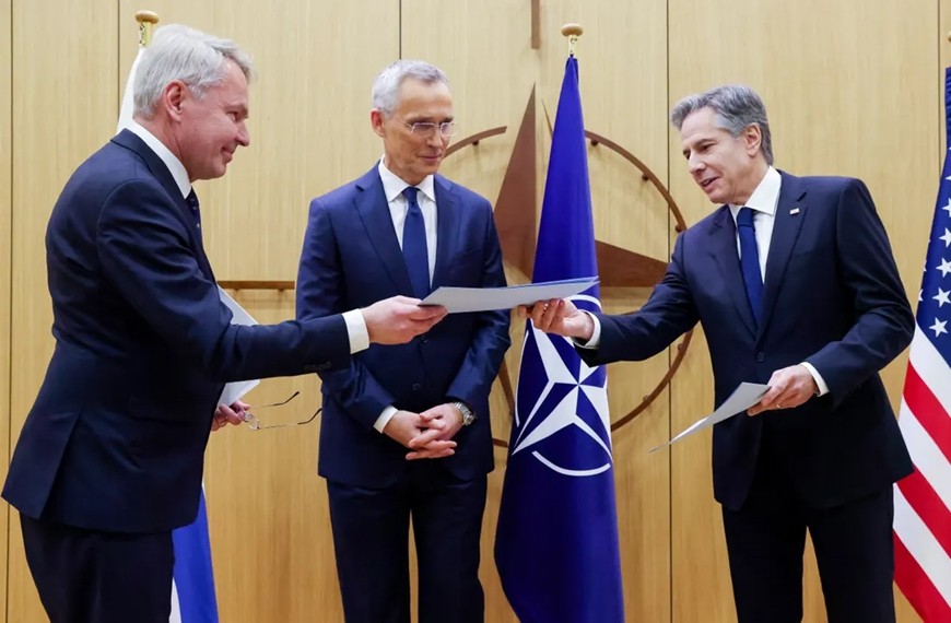 Ngoại trưởng Phần Lan Pekka Haavisto (trái) trao văn kiện gia nhập NATO của nước này cho Ngoại trưởng Mỹ Antony Blinken (phải) dưới sự chứng kiến của Tổng thư ký NATO Jens Stoltenberg. Ảnh: The Guardian