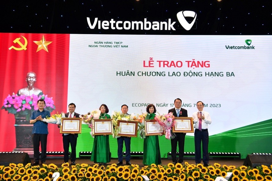 Đ/c Đào Minh Tú - Phó Bí thư Ban cán sự Đảng, Phó Thống đốc thường trực Ngân hàng Nhà nước Việt Nam, Ủy viên BCH Tổng Liên đoàn Lao động Việt Nam, Chủ tịch Công đoàn Ngân hàng Việt Nam (ngoài cùng bên phải) và đ/c Nguyễn Đức Phong - Phó Bí thư Thường trực Đảng ủy Khối Doanh nghiệp TW (ngoài cùng bên trái) thực hiện nghi thức khen thưởng cho 5 cá nhân được trao tặng Huân chương Lao động hạng Ba