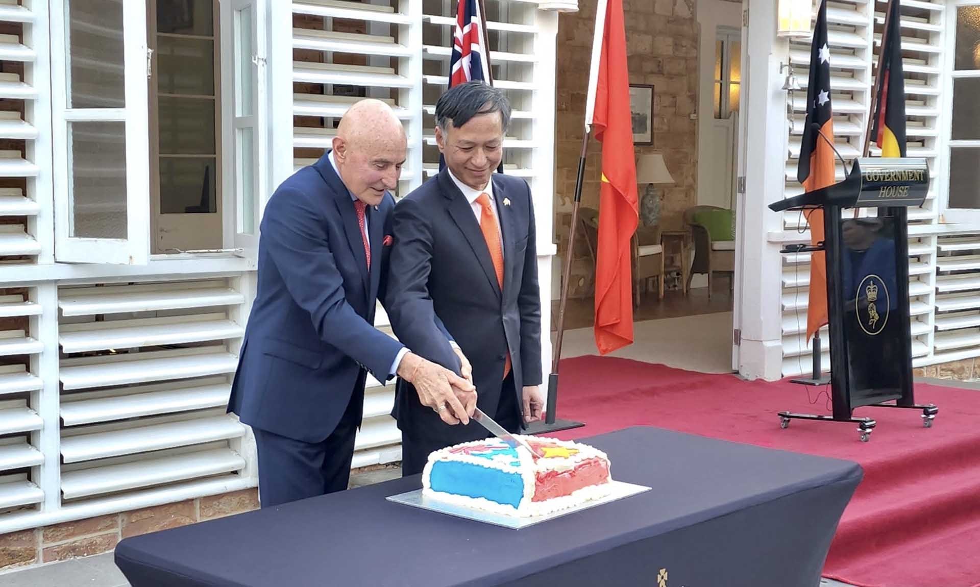 Thống đốc và Đại sứ thực hiện nghi lễ cắt bánh tại lễ kỷ niệm.
