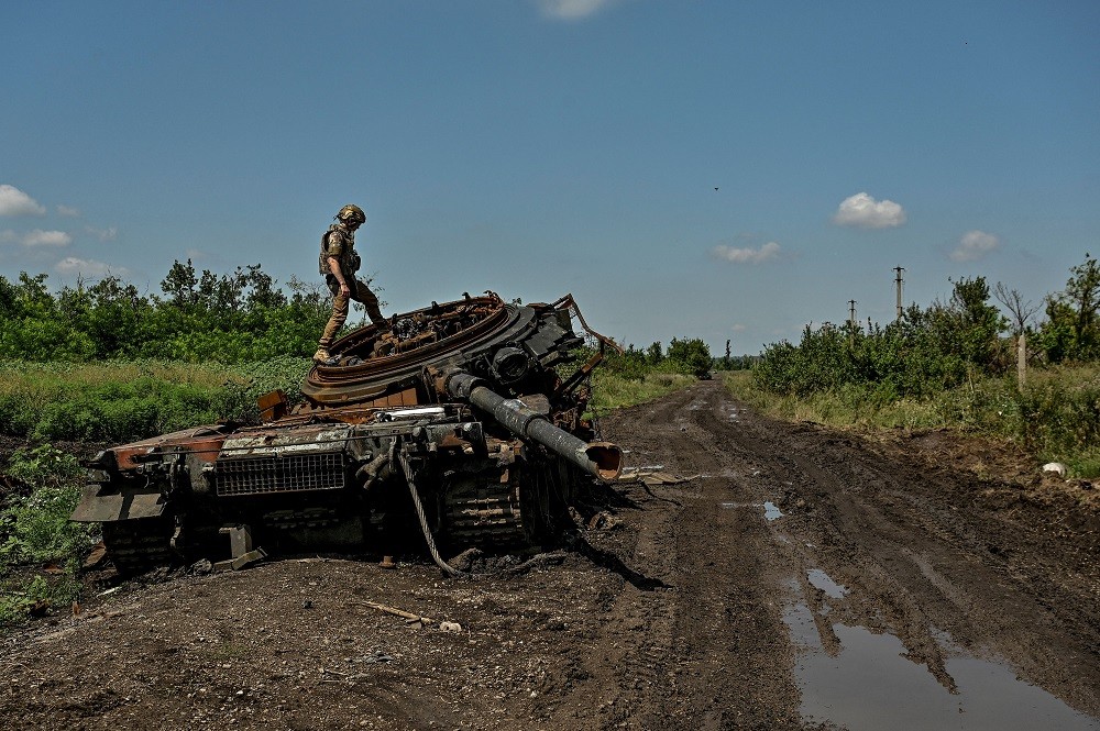 (07.28) Một binh sĩ Ukraine kiểm tra xe tăng bị phá hủy của Nga ở khu vực Donetsk ngày 21/7. (Nguồn: AFP/Getty Images)