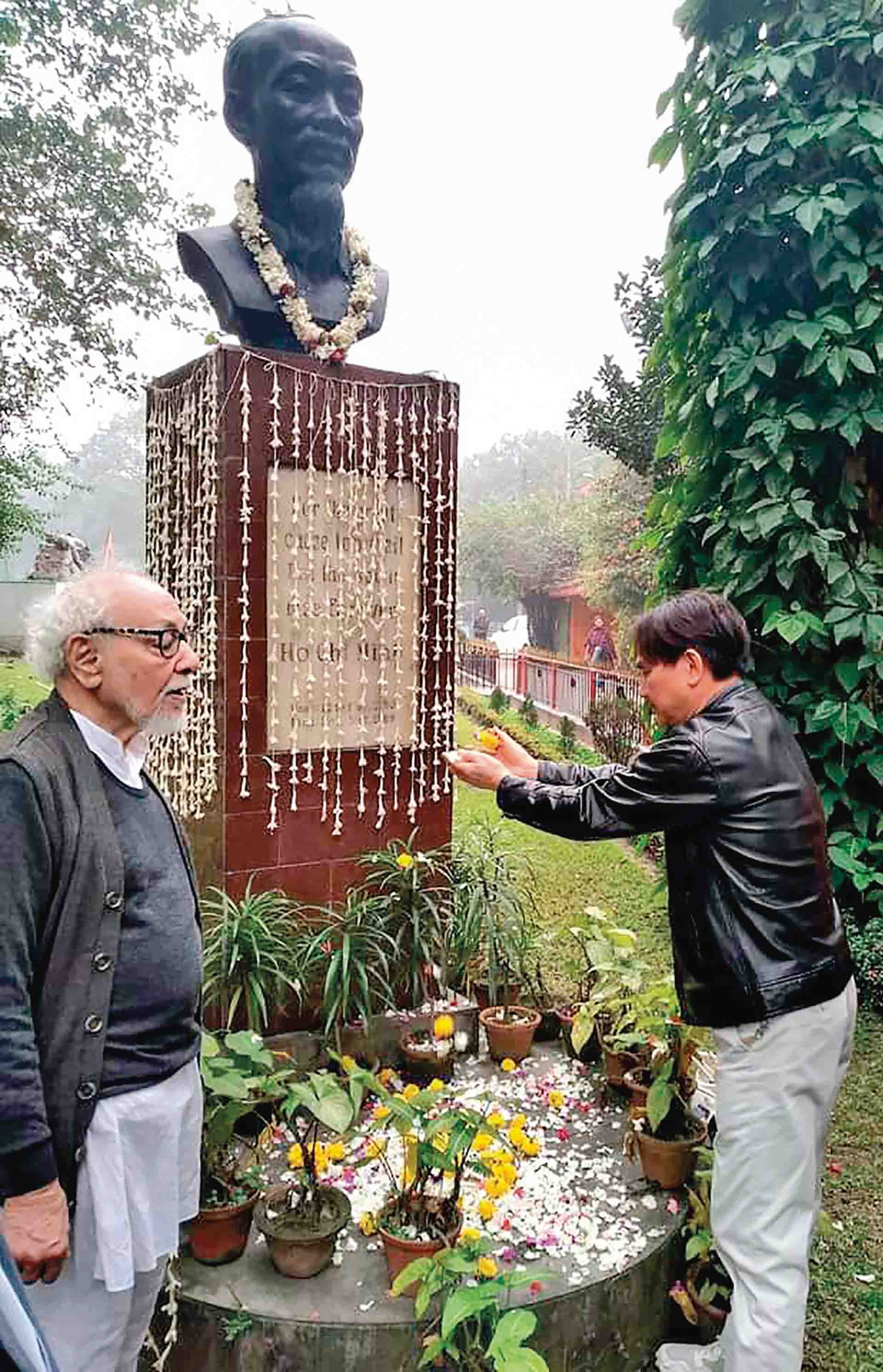 Nhà văn Thế Đức rắc hoa tươi xung quanh tượng đài Bác Hồ ở công viên Chiến thắng, thành phố Kolkata, bang Tây Bengal, Ấn Độ. (Ảnh: TGCC)