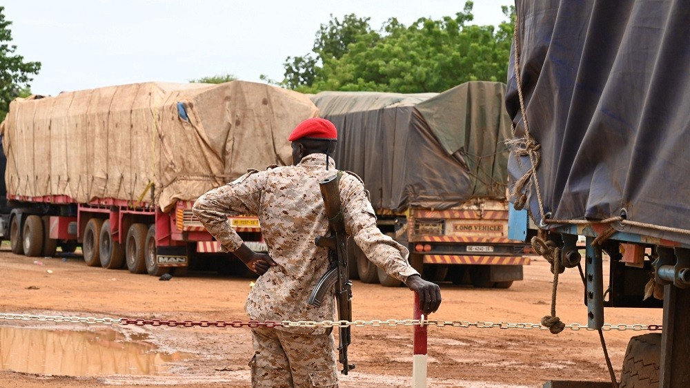 (08.22) Binh sĩ canh giữ các xe chở lương thực từ Burkina Faso tới Niger. (Nguồn: Getty Images)