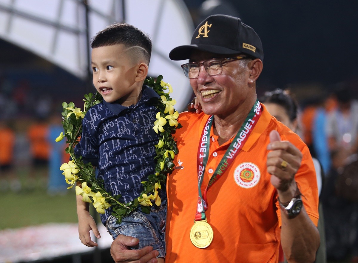 Bố của Văn Hậu đeo Huy chương vàng chụp ảnh cùng cháu nội. 