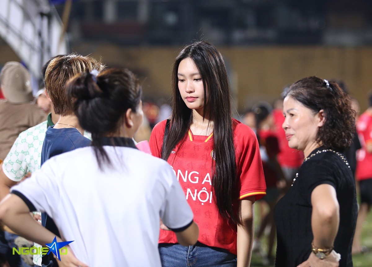 Hải My sau đó vẫn đứng ở sân chờ bạn trai. Cô trò chuyện cùng nhóm người quen, trong đó có mẹ tiền vệ Quang Hải (ngoài cùng bên phải). 