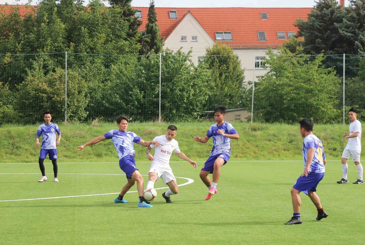 Pha tranh bóng giữa các cầu thủ đội FC Berlin (áo trắng) với đội FC Miền Trung. Ảnh: Phương Hoa -TTXVN