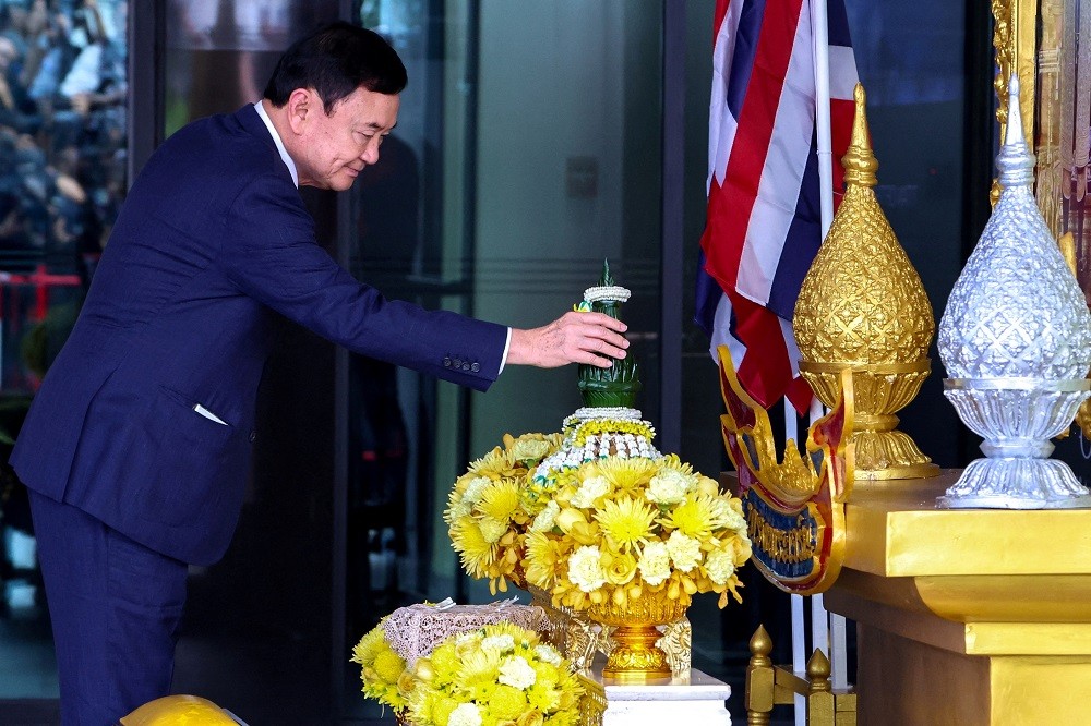(09.05) Cựu Thủ tướng Thaksin Shinawatra thực hiện nghi lễ bày tỏ sự tôn trọng với Nhà vua Maha Vajiralongkorn và Hoàng hậu Suthida khi trở về nước ngày 22/8. (Nguồn: Reuters)
