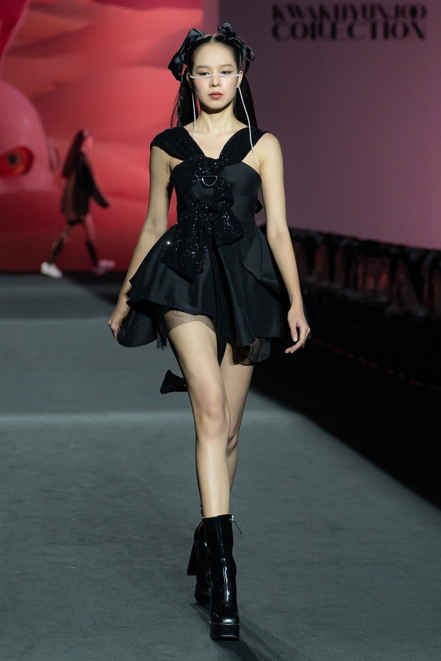 Hoa hậu Thanh Thủy khoe đôi chân thẳng dài với đầm đen ngắn của nhà thiết kế Kwak Hyun Joo. Diện trang phục nữ tính nhưng mỹ nhân 21 tuổi vẫn giữ thần thái sắc lạnh. Cô được khen catwalk mềm mại, uyển chuyển trên đường băng.