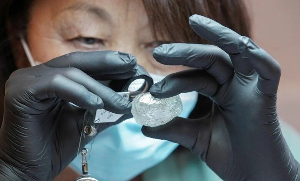Một nhân viên của công ty Alrosa (Nga) kiểm tra một viên kim cương thô 242 carat được đưa ra đấu giá vào năm 2021. (Nguồn: Reuters).