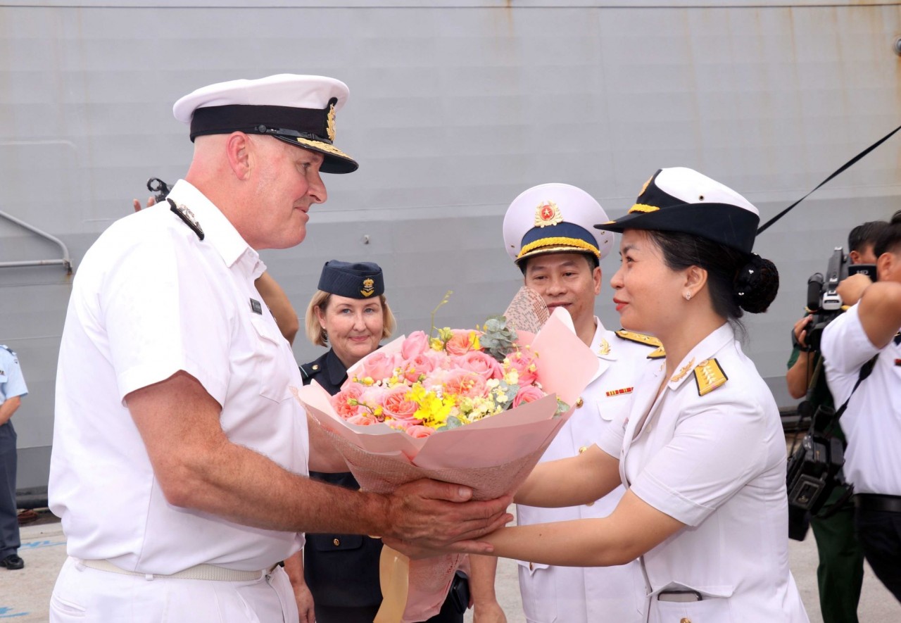 Nữ chiến sỹ hải quân Việt Nam tặng hoa chào mừng Chuẩn Đô đốc James Gilmmour, Tư lệnh Liên quân New Zealand. (Nguồn: TTXVN)