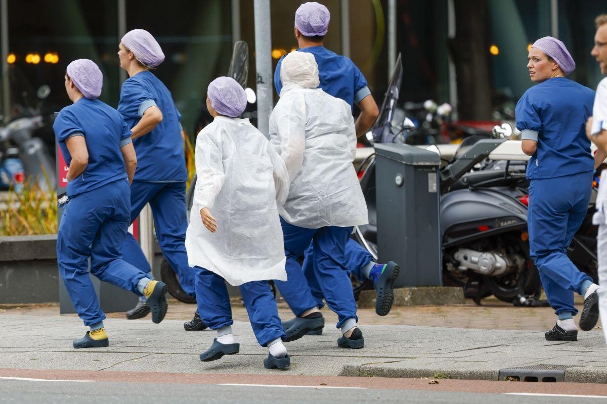 Nhân viên y tế rời khỏi bệnh viện Erasmus MC đã bị phong tỏa sau khi có báo cáo về vụ nổ súng. (Nguồn: AFP)