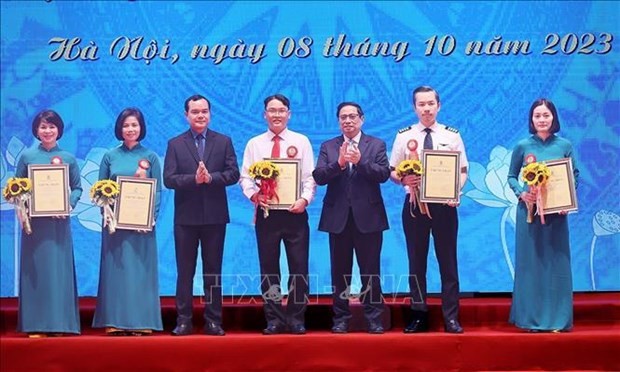 Prime Minister Pham Minh Chinh (third from righ) presents awards to those with outstanding initiatives. (Photo: VNA)