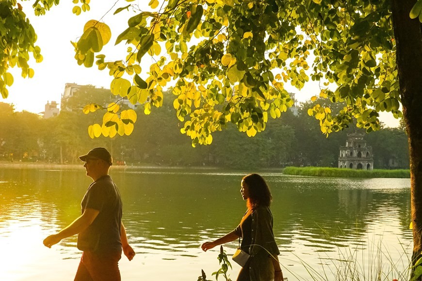 Khánh du lịch thư thái đi dạo bên hồ Hoàn Kiếm, dưới nắng vàng mùa Thu Hà Nội. (Nguồn: TTXVN)