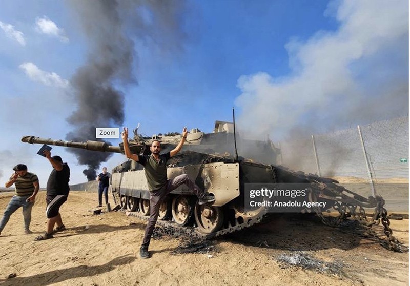 Các chiến binh Hamas và một chiếc xe tăng Israel bị phá hủy Ảnh Anadolu