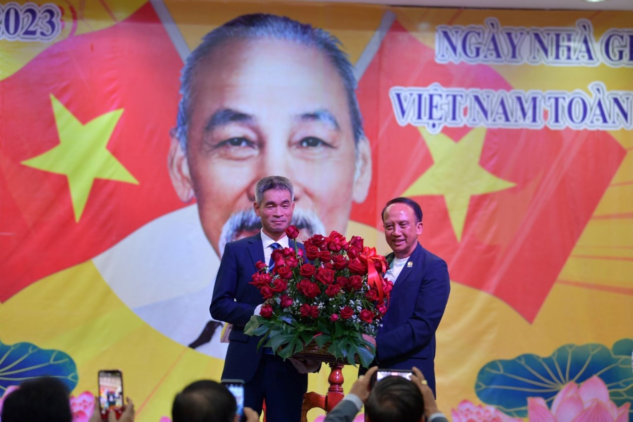 Tổng lãnh sự Việt Nam tại Khon Kaen Chu Đức Dũng (bìa trái) tặng hoa chúc mừng các thầy cô giáo. (Nguồn: TTXVN)