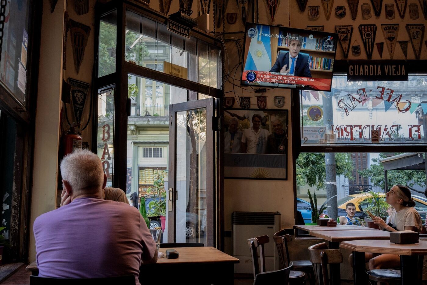 Khách hàng xem tivi trong bài phát biểu của Luis Caputo, tại một quán bar ở Buenos Aires, vào ngày 12 tháng 12.Nhiếp ảnh gia: Anita Pouchard Serra/Bloomberg