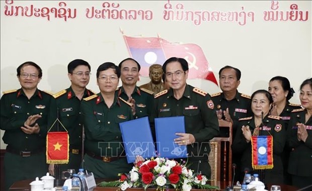 Representatives of Military Hospital 103 of the Vietnam People's Army and Central Hospital 103 of the Lao People's Army exchange the minutes of their discussion at the event. (Photo: VNA)