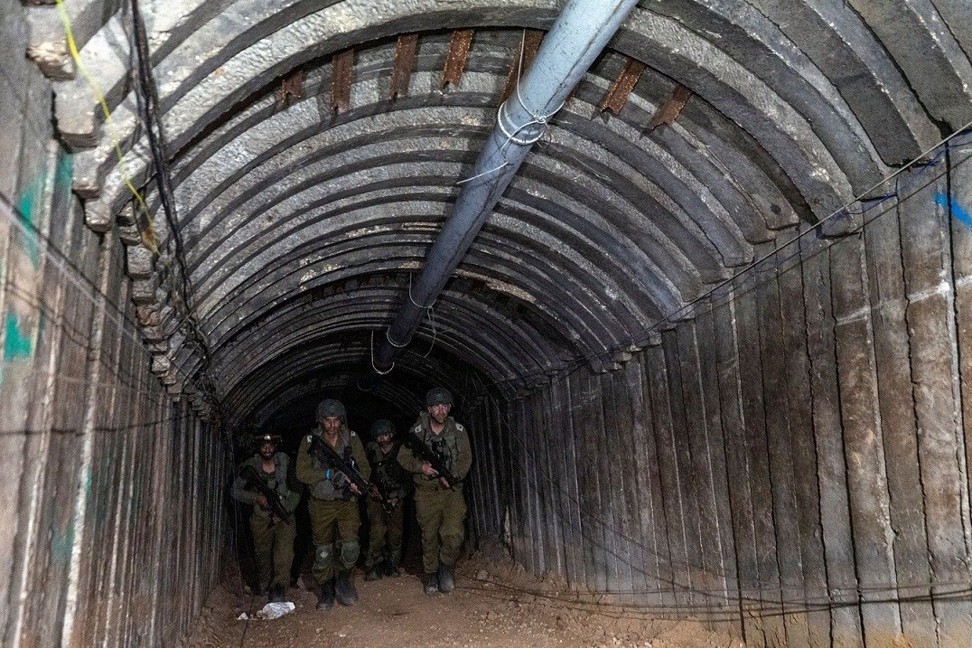 Binh sĩ Israel đi qua nơi mà quân đội nước này cho là một đường hầm của lực lượng Hamas để vận chuyển binh sĩ chuẩn bị tấn công bất ngờ vào biên giới, trong bối cảnh Nhà nước Hồi giáo đang tiến hành chiến dịch trên bộ chống lại đối phương, gần cửa khẩu Er