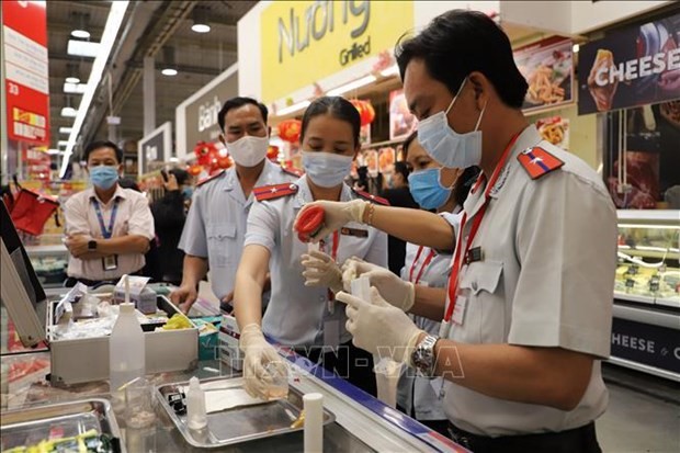 Food safety officials examine food at a restaurant.  (Photo: VNA)