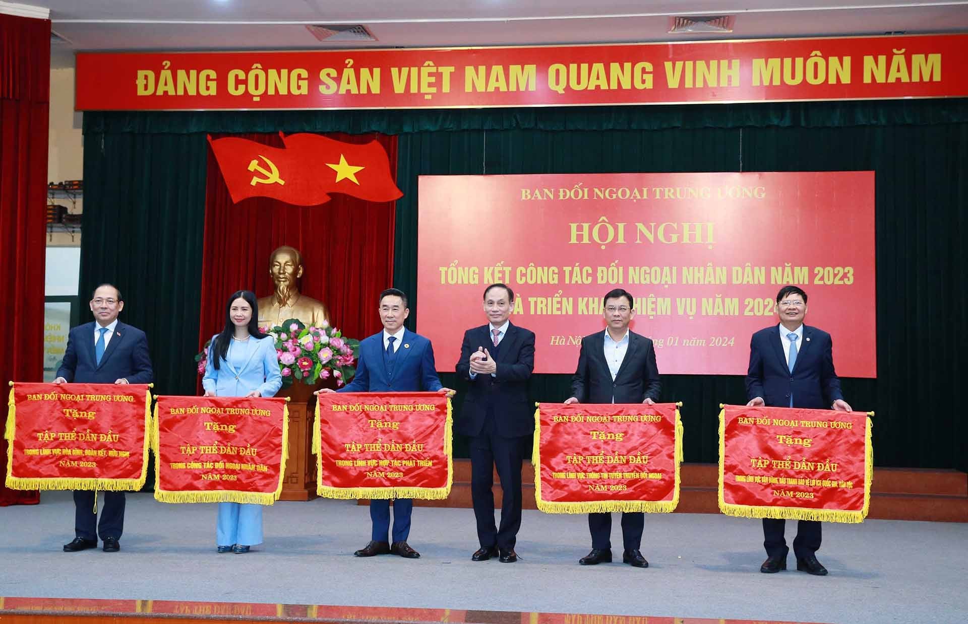 Đồng chí Lê Hoài Trung, Bí thư Trung ương Đảng, Trưởng ban Đối ngoại Trung ương trao Cờ thi đua cho các tập thể có thành tích xuất sắc. (Nguồn: TTXVN)