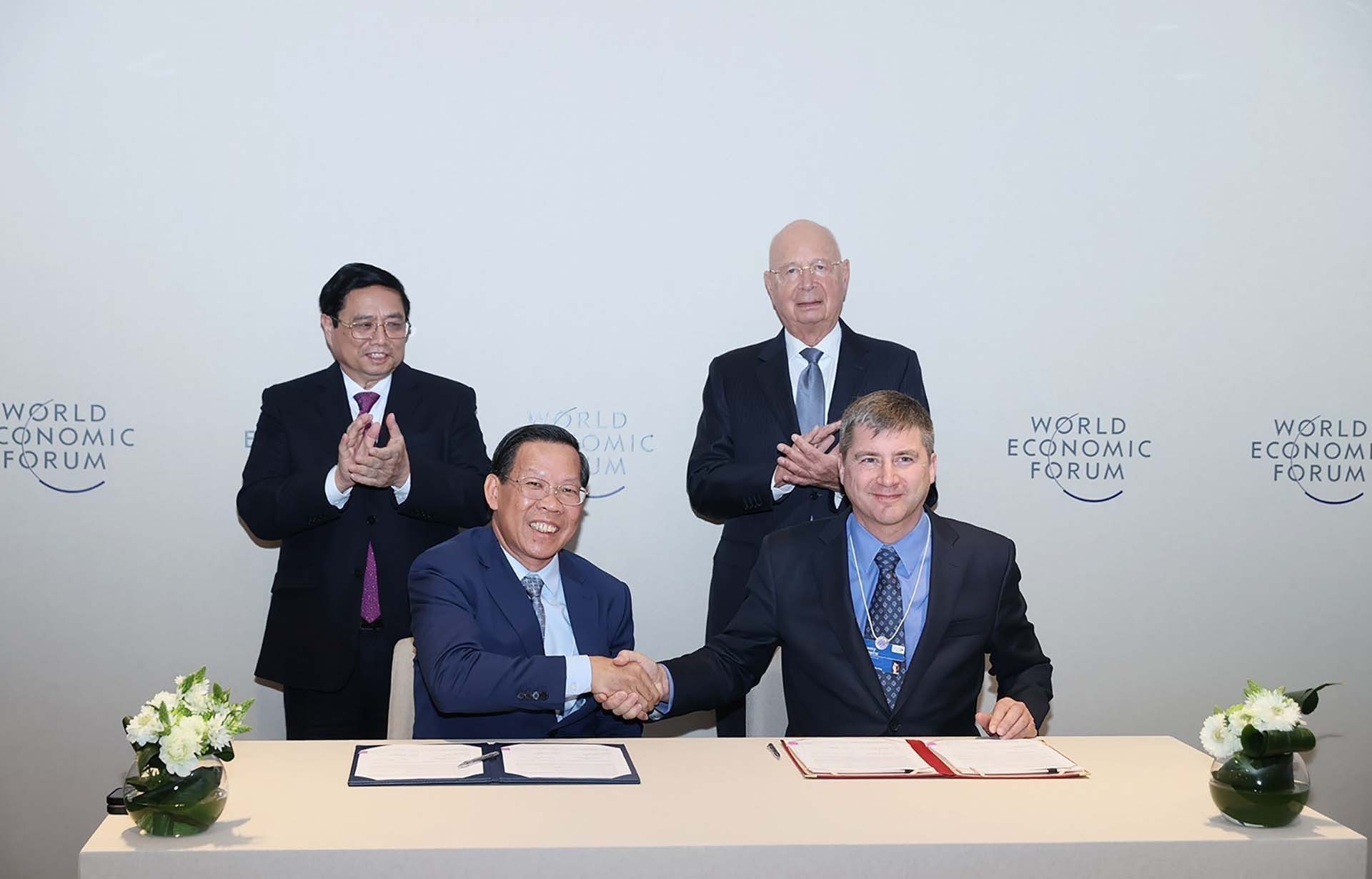 Thủ tướng Phạm Minh Chính và Giáo sư Klaus Schwab chứng kiến ký kết biên bản ghi nhớ hợp tác giữa UBND TP. Hồ Chí Minh và WEF. (Nguồn: TTXVN)
