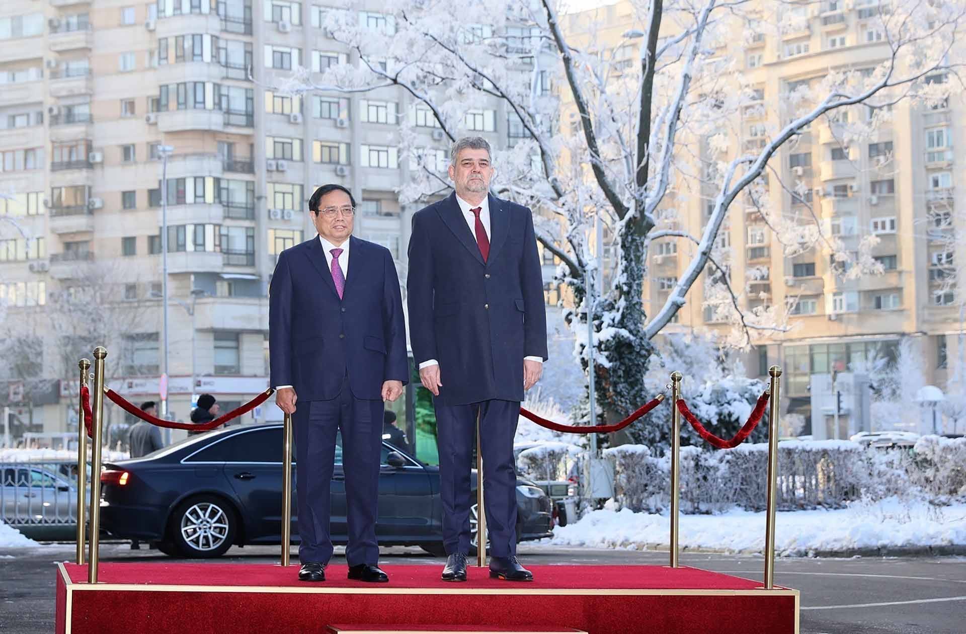 Thủ tướng Phạm Minh Chính và Thủ tướng Romania Ion-Marcel Ciolacu nghe quân nhạc cử Quốc thiều hai nước. (Nguồn: TTXVN)
