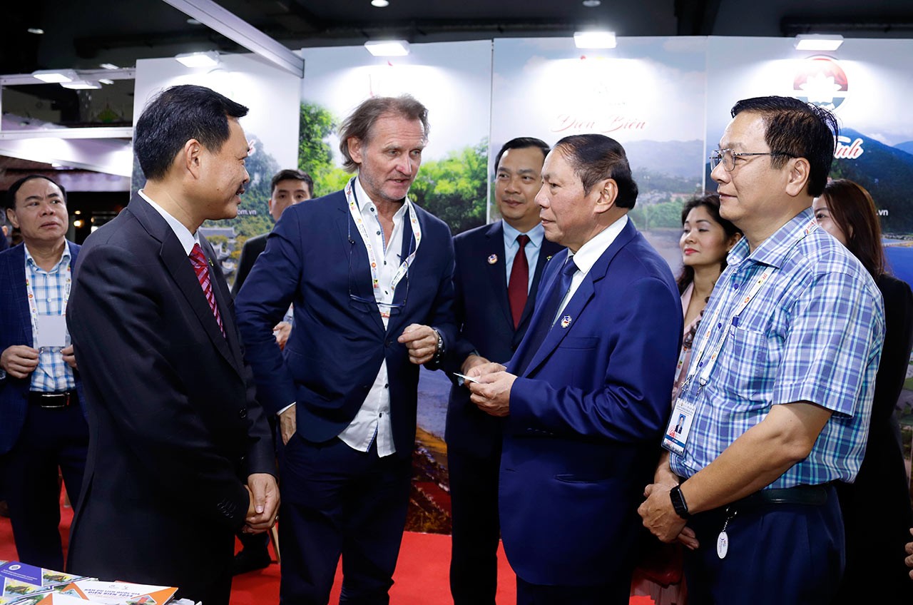 Bộ trưởng Bộ Văn hoá, Thể thao và Du lịch Việt Nam Nguyễn Văn Hùng trao đổi với khách hàng đến thăm Gian hàng của Việt Nam tại Hội chợ. (Nguồn: TTXVN)