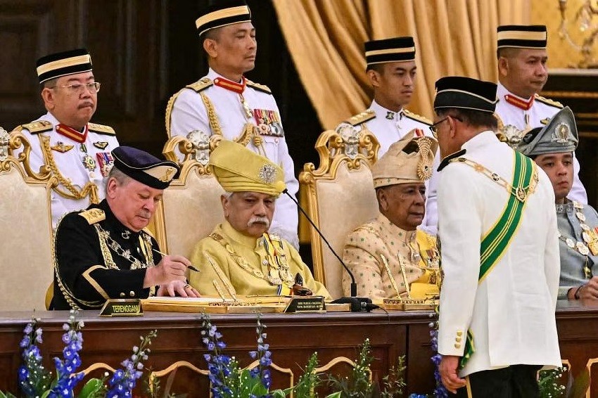 Quốc vương Ibrahim Iskandar (trái) ký các văn bản nhận được từ Thủ tướng Anwar Ibrahim (phải) tại buổi lễ.