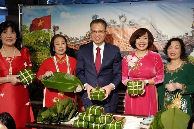 Đại sứ Việt Nam tại LB Nga Đặng Minh Khôi (giữa) và Phu nhân (thứ 2, phải qua) cùng bà con cộng đồng gói bánh chưng. Ảnh: TTXVN