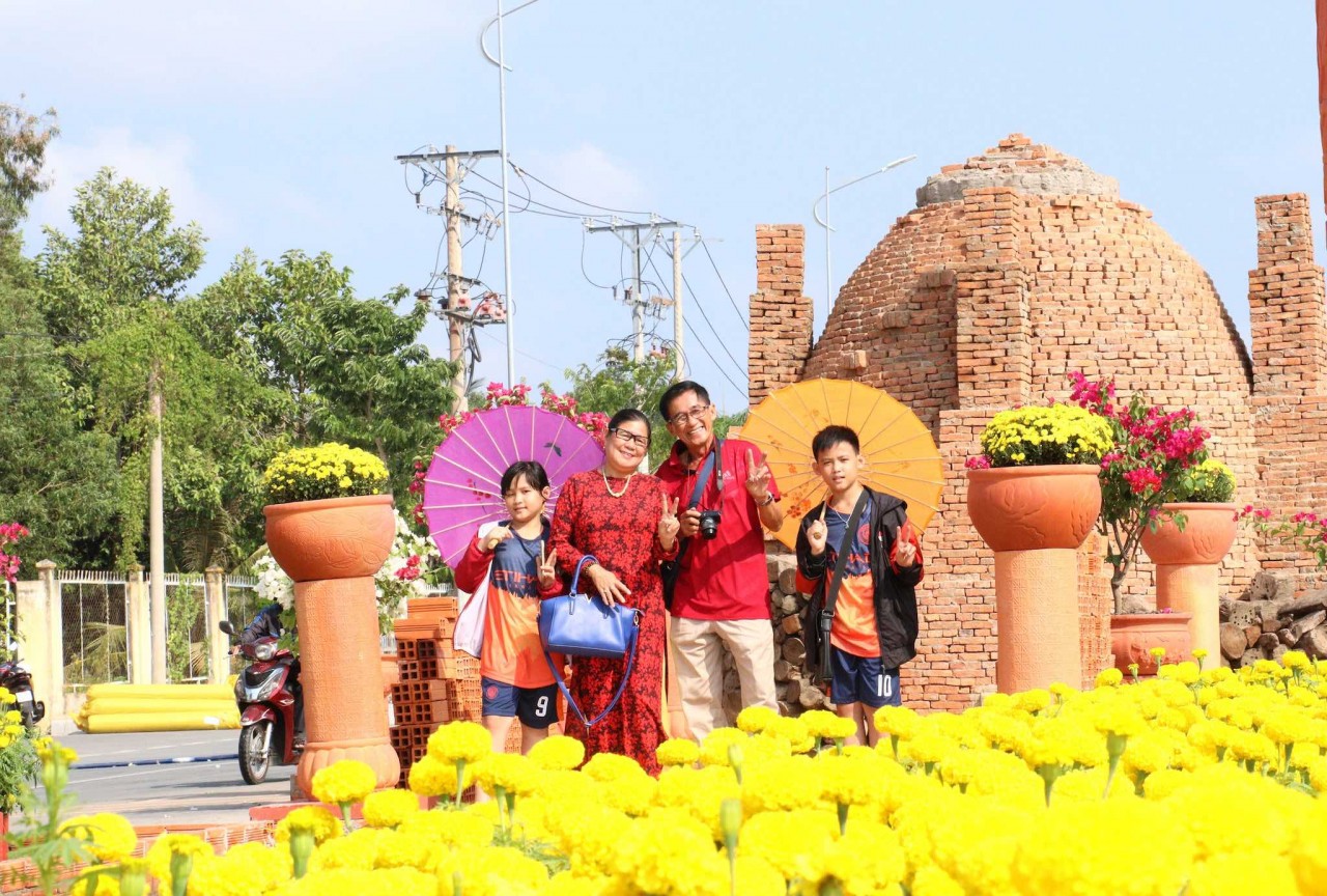Người dân phấn khởi đi chụp ảnh trên con đường gốm và hoa xuân Giáp Thìn năm 2024 tại thành phố Vĩnh Long, tỉnh Vĩnh Long. (Ảnh: Lê Thúy Hằng/TTXVN)