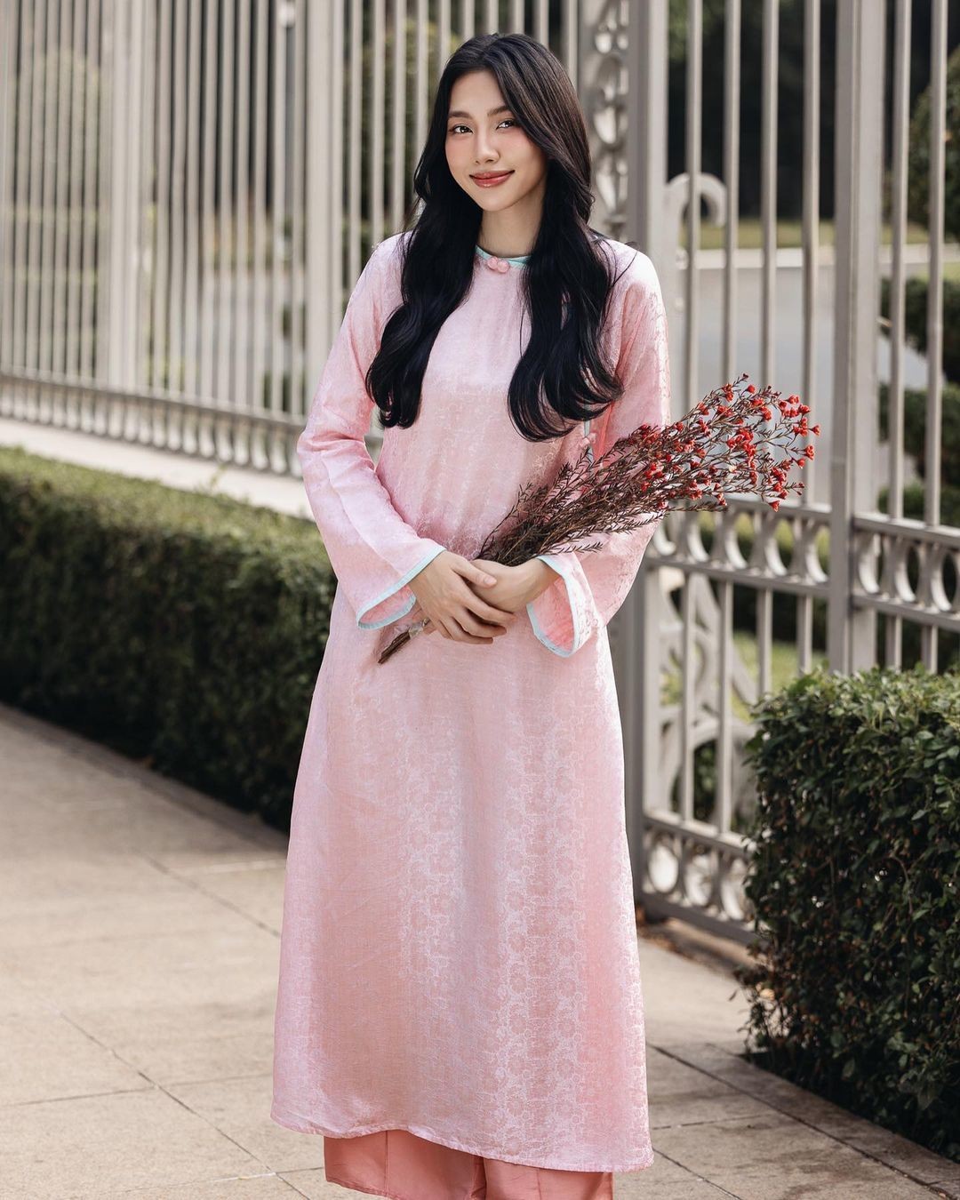 Hoa hậu Thùy Tiên trang điểm tông hồng đất ăn ý với tà áo.