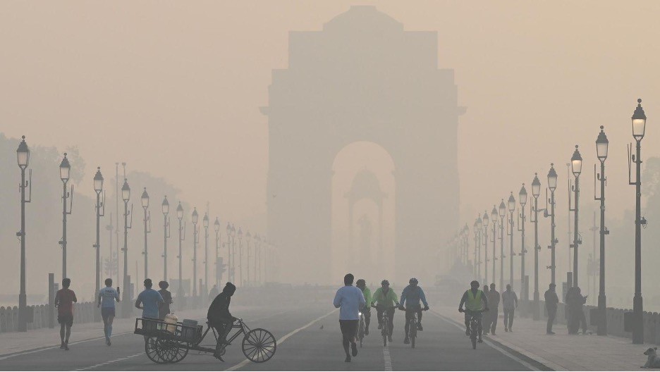 Người đi bộ tập thể dục buổi sáng trong thời tiết lạnh giá và bụi mịn bao phủ trên đường Kartavya Path gần India Gate, New Delhi, Ấn Độ. (Nguồn: Hindustan Times)