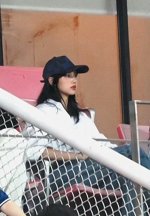 Lisa xuất hiện trên sân vận động, theo dõi trận vòng loại World Cup giữa Thái Lan và Hàn Quốc, diễn ra tại quê nhà. Ca sĩ mặc khỏe khoắn, đội mũ lưỡi trai, trang điểm nhẹ.