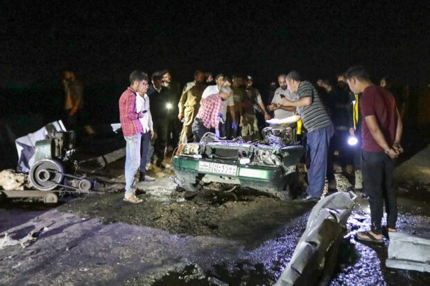 Người dân tụ tập quanh xác ô tô sau vụ nổ bom xe ở thị trấn Shawa phía Bắc Syria, gần biên giới với Thổ Nhĩ Kỳ, ngày 9/7/2023. (Nguồn: AFP)