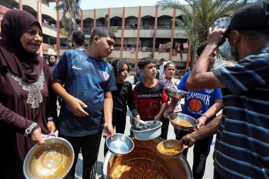 Người Palestine tụ tập để nhận bữa ăn do World Central Kitchen nấu tại một trường học dành cho người di tản ở trung tâm Dải Gaza. (NGuồn: NYTimes)