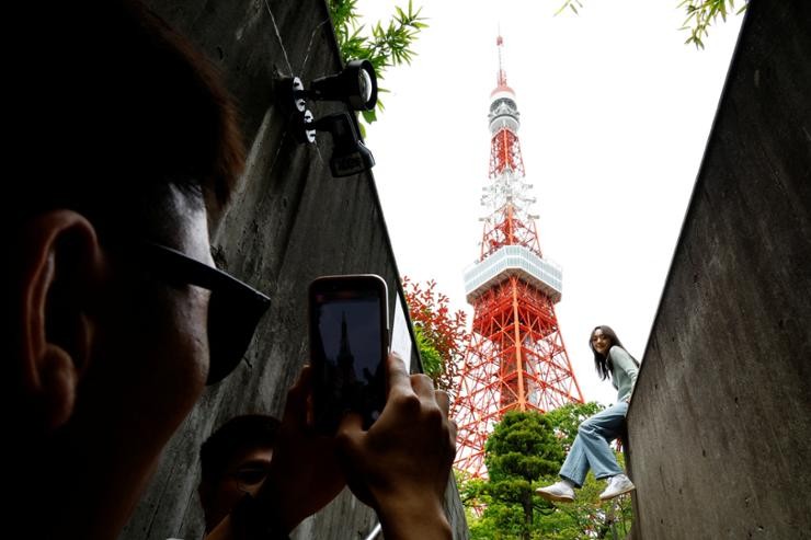 Tourists take photos in front of Tokyo Tower in Tokyo, April 26. The number of Korean visitors to Japan last month was more than 661,200, a record high in April. (Source: Reuters-Yonhap)