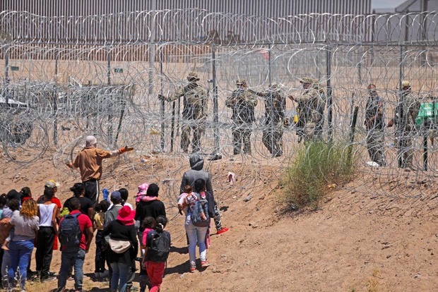 Những người di cư tìm cách vào Hoa Kỳ thông qua hàng rào thép gai dọc sông Rio Grande bị đặc vụ Vệ binh Quốc gia Texas xua đuổi bằng hơi cay tại biên giới với Ciudad Juárez, Mexico, vào ngày 13 tháng 5 năm 2024.
