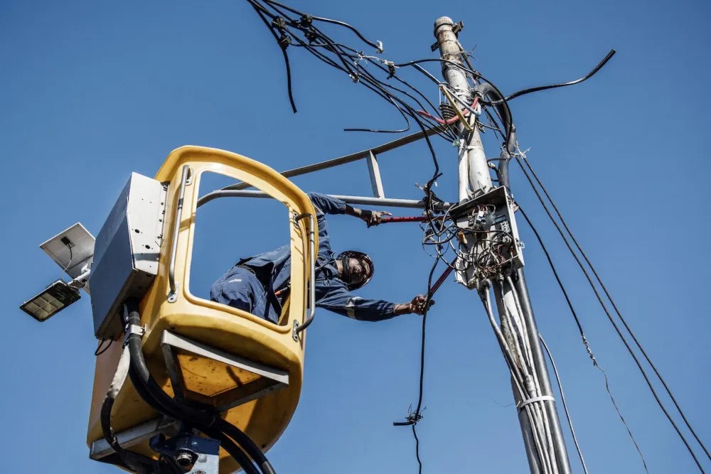 Một nhân viên điện lực thành phố tháo dây cáp điện nối trái phép ở Johannesburg, Nam Phi, vào ngày 9/6/2022.