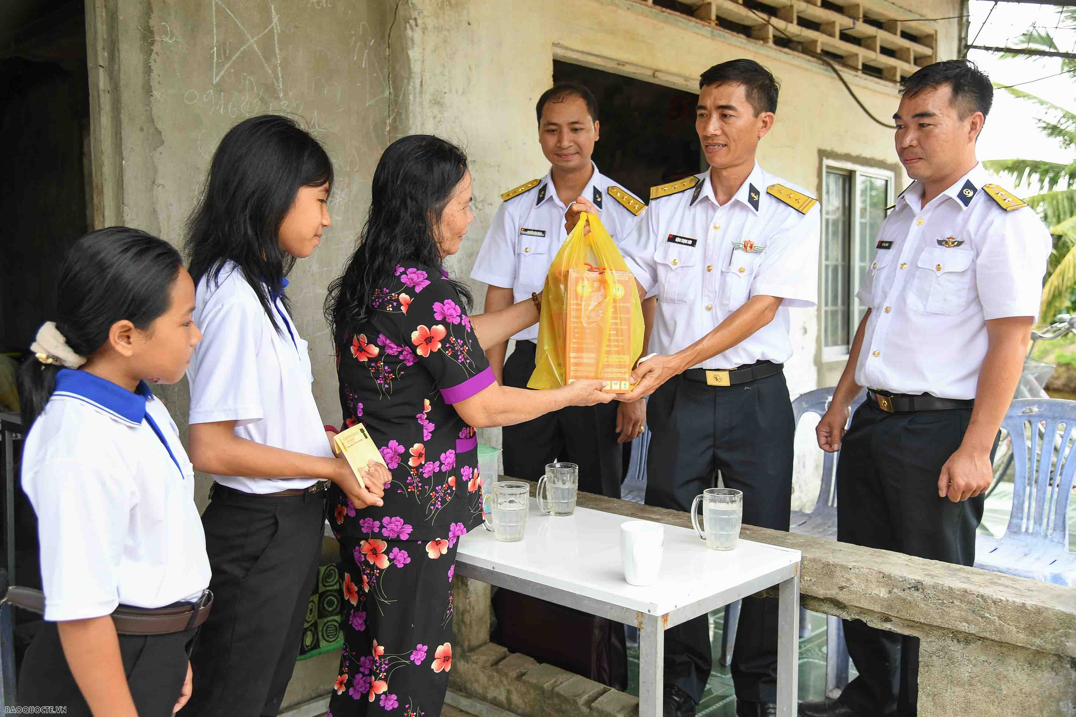 Thượng tá Đặng Trọng Sơn trao tiền hỗ trợ cho em Lã Thị Khánh Linh. (Ảnh: Văn Định)