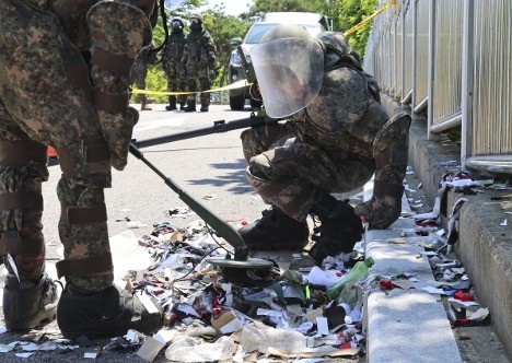 Binh sĩ Hàn Quốc mặc đồ bảo hộ kiểm tra một quả bóng mang rác được cho là do Triều Tiên gửi đến. (Nguồn: AP)