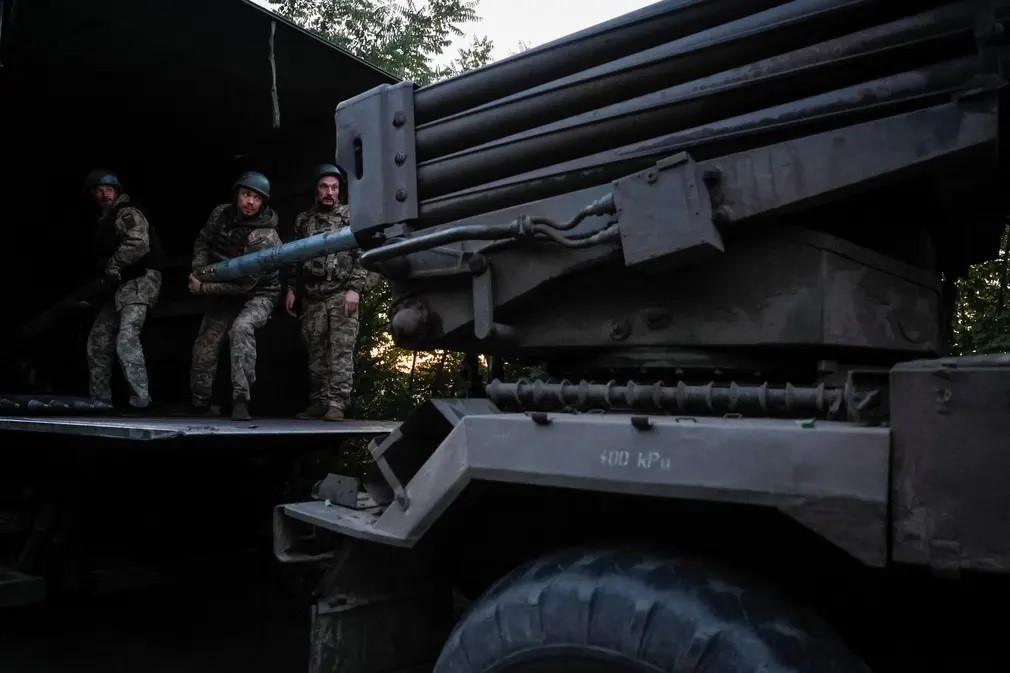 Các quân nhân Ukraine thuộc Lữ đoàn cơ giới riêng biệt số 110 Marko Bezruchko nạp đạn vào hệ thống phóng tên lửa đa nòng khi chuẩn bị bắn về phía quân đội Nga gần tiền tuyến ở Donetsk. (Nguồn: Reuters)