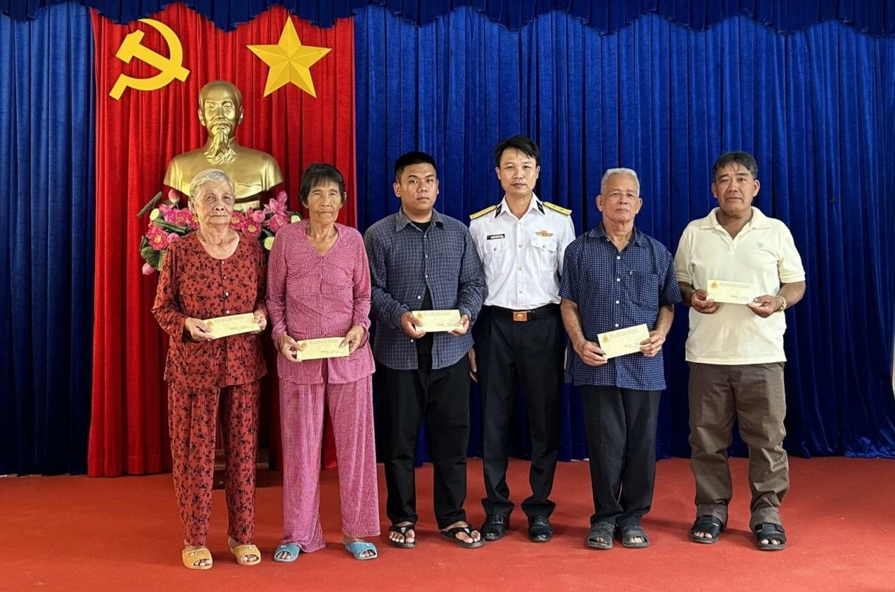 Trung tá Nguyễn Trung Thông, Phó Chính ủy Trung tâm Bảo đảm Kỹ thuật-Hậu cần trao quà tặng các gia đình chính sách.