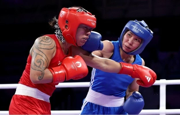 Ha Thi Linh (right) lands a punch on Feofaaki Epenisa from Tonga during the Paris Olympics' women's 60kg first round match on July 27. (Photo doisongphapluat.com.vn)