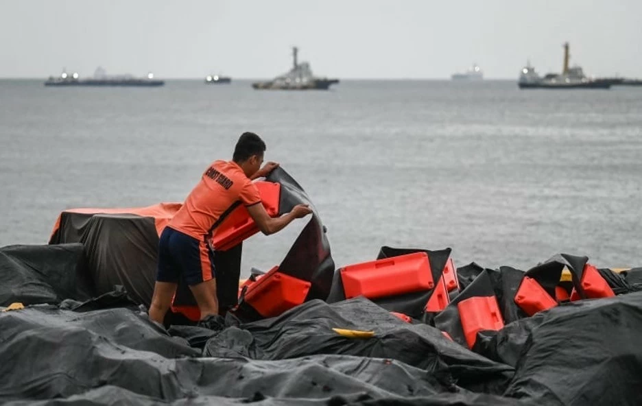 Một thành viên của lực lượng bảo vệ bờ biển đang chuẩn bị phao chắn tràn dầu để triển khai tại một cảng ở Limay, Bataan, hôm 25/7. (Nguồn: AFP)