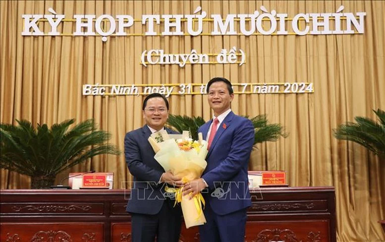 Bí thư Tỉnh ủy Bắc Ninh Nguyễn Anh Tuấn (bên trái) tặng hoa chúc mừng Chủ tịch UBND tỉnh khóa XIX, nhiệm kỳ 2021-2026 Vương Quốc Tuấn.
