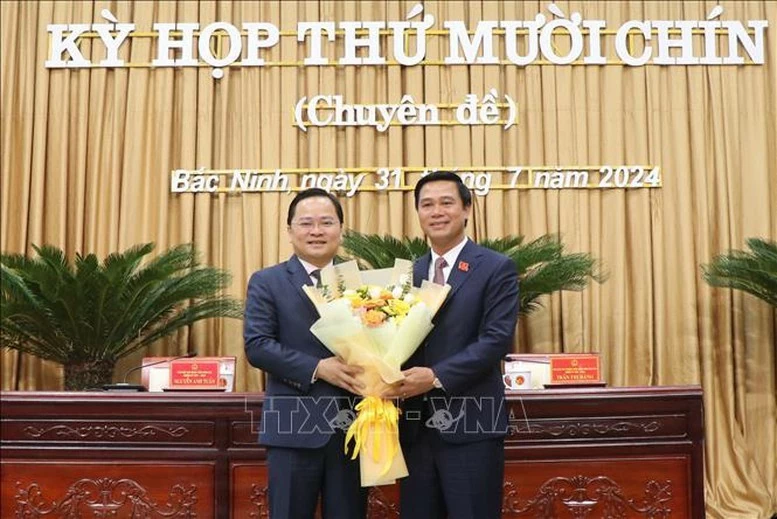 Bí thư Tỉnh ủy Bắc Ninh Nguyễn Anh Tuấn (bên trái) tặng hoa chúc mừng Phó Chủ tịch UBND tỉnh Bắc Ninh Lê Xuân Lợi.