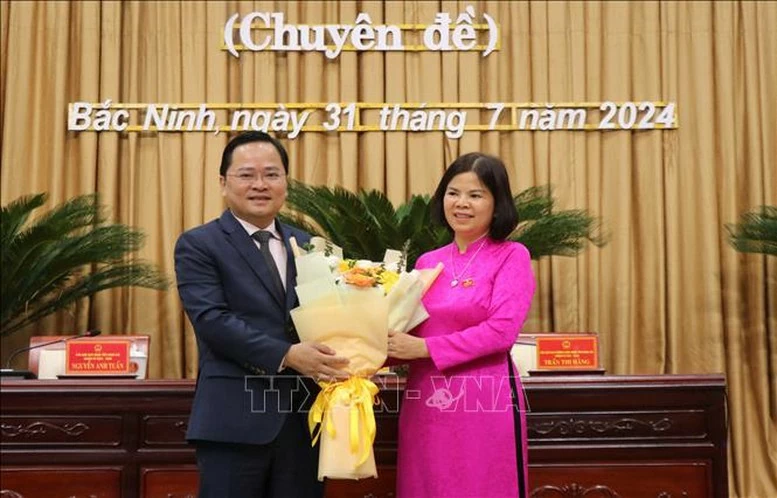 Bí thư Tỉnh ủy Bắc Ninh Nguyễn Anh Tuấn (bên trái) tặng hoa chúc mừng Chủ tịch HĐND tỉnh khóa XIX, nhiệm kỳ 2021 - 2026 Nguyễn Hương Giang.
