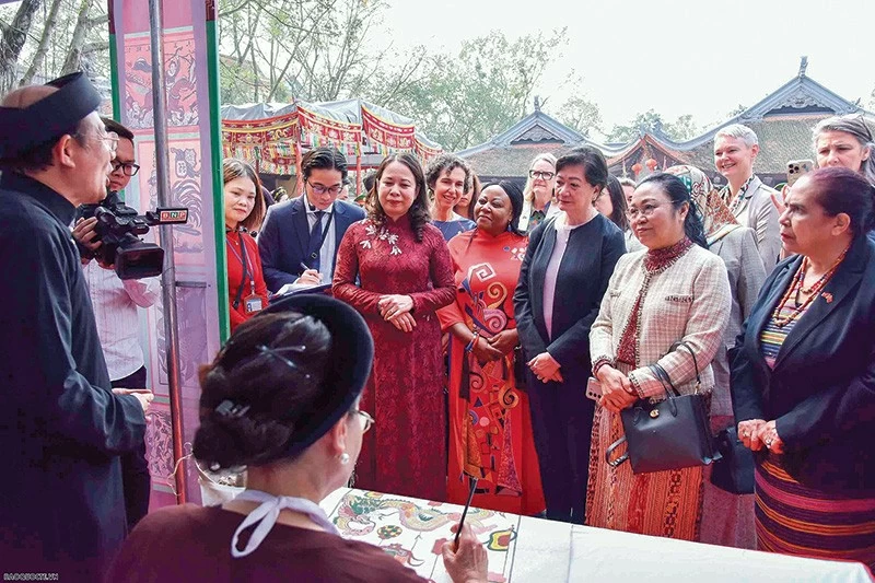 Phó Chủ tịch nước cùng các nữ Trưởng cơ quan đại diện nước ngoài tại Việt Nam xem các nghệ nhân làm tranh Đông Hồ. 