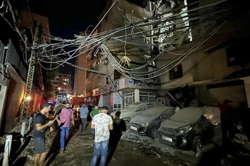 Người dân tập trung gần một tòa nhà bị phá hủy do cuộc không kích của Israel ở vùng ngoại ô phía Nam Beirut, Lebanon, ngày 30/7. (Nguồn: AP)
