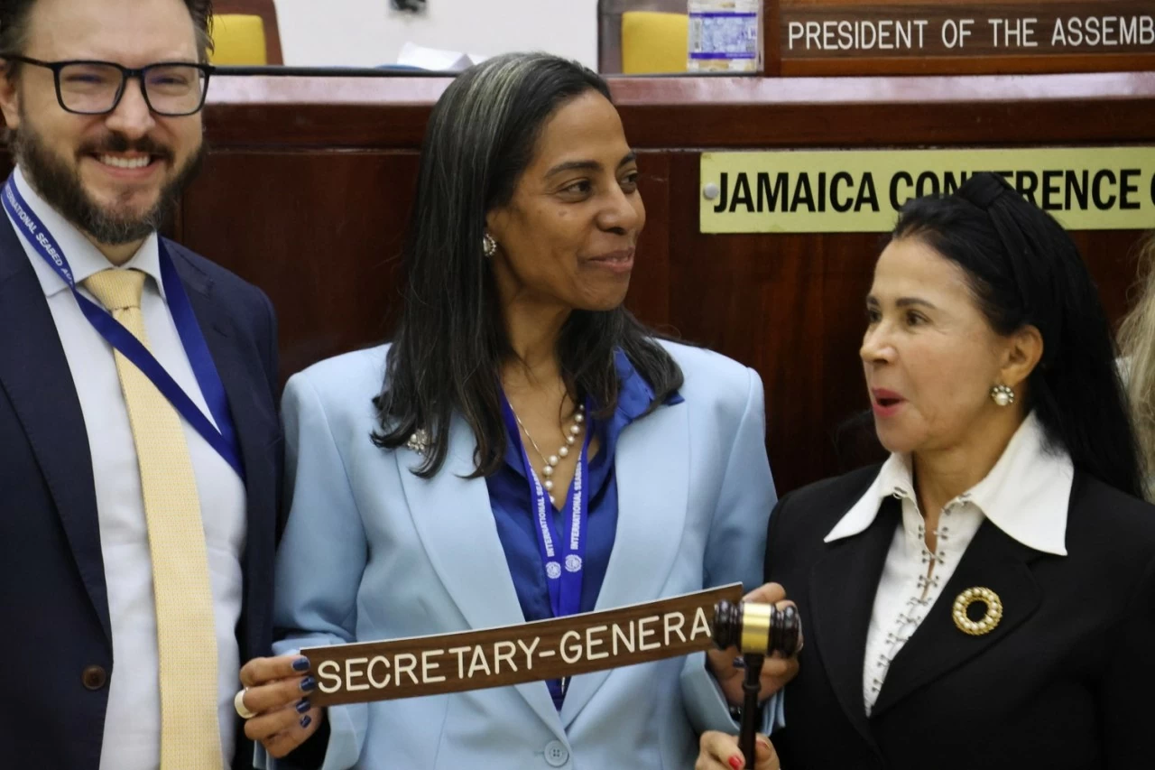 Bà Leticia Carvalho đến từ Brazil (ở giữa), tổng thư ký đắc cử của Cơ quan quản lý đáy biển quốc tế, được một đại biểu của ISA chúc mừng ngày 2/8. (Nguồn: Benar News)